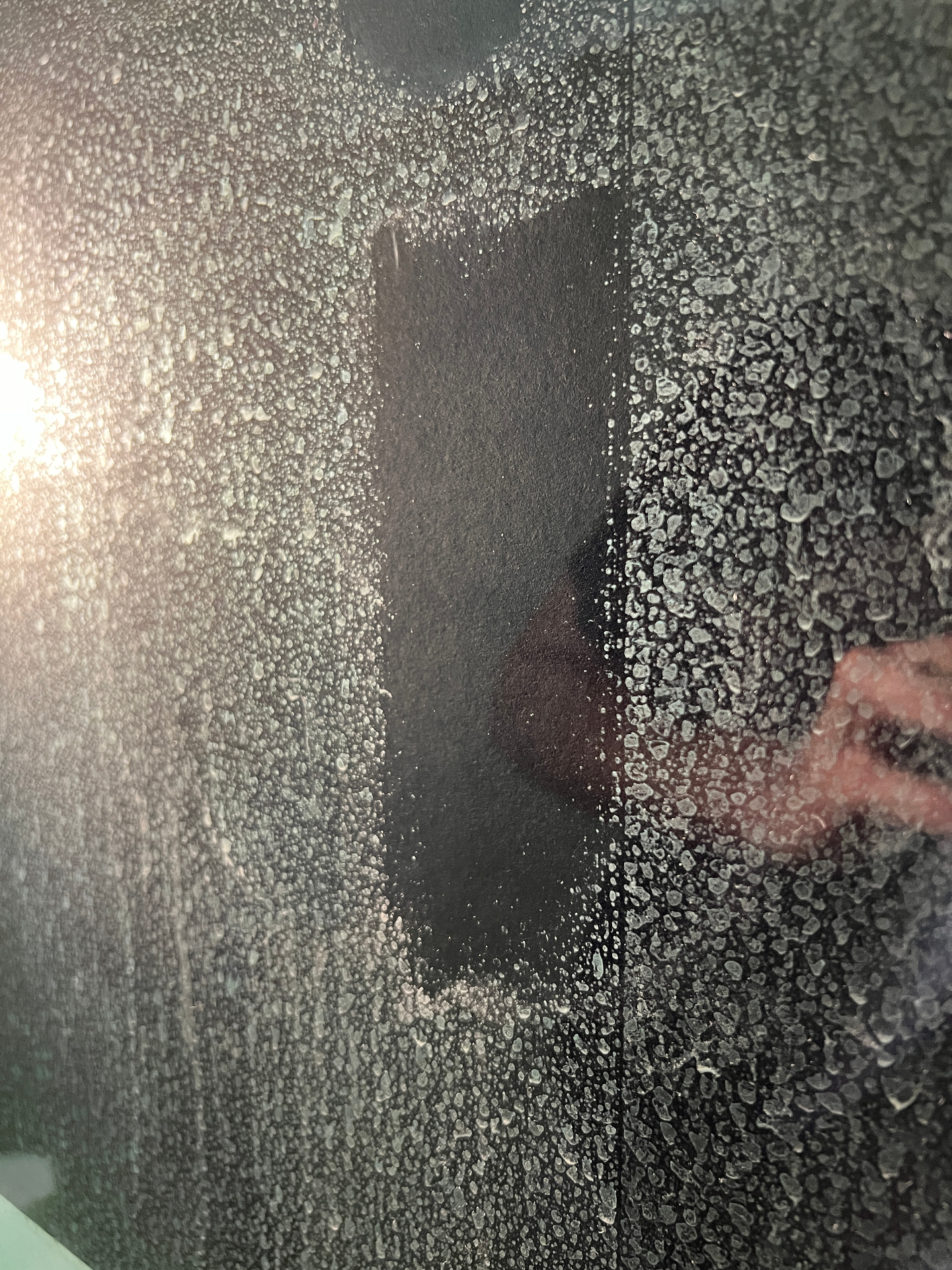 Kalk- und Mineralrückstände auf einer Glasfläche im Detail