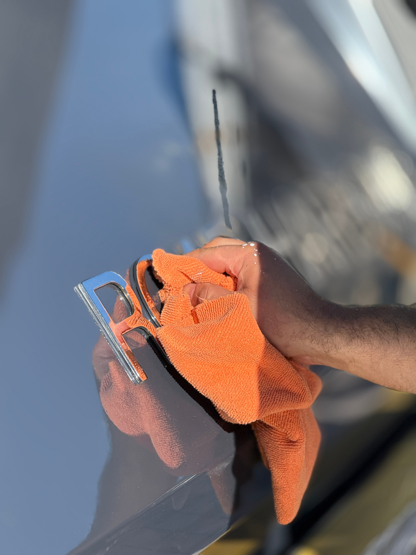 Detailpflege eines Edelstahlbeschlags mit Mikrofasertuch auf einer Yacht